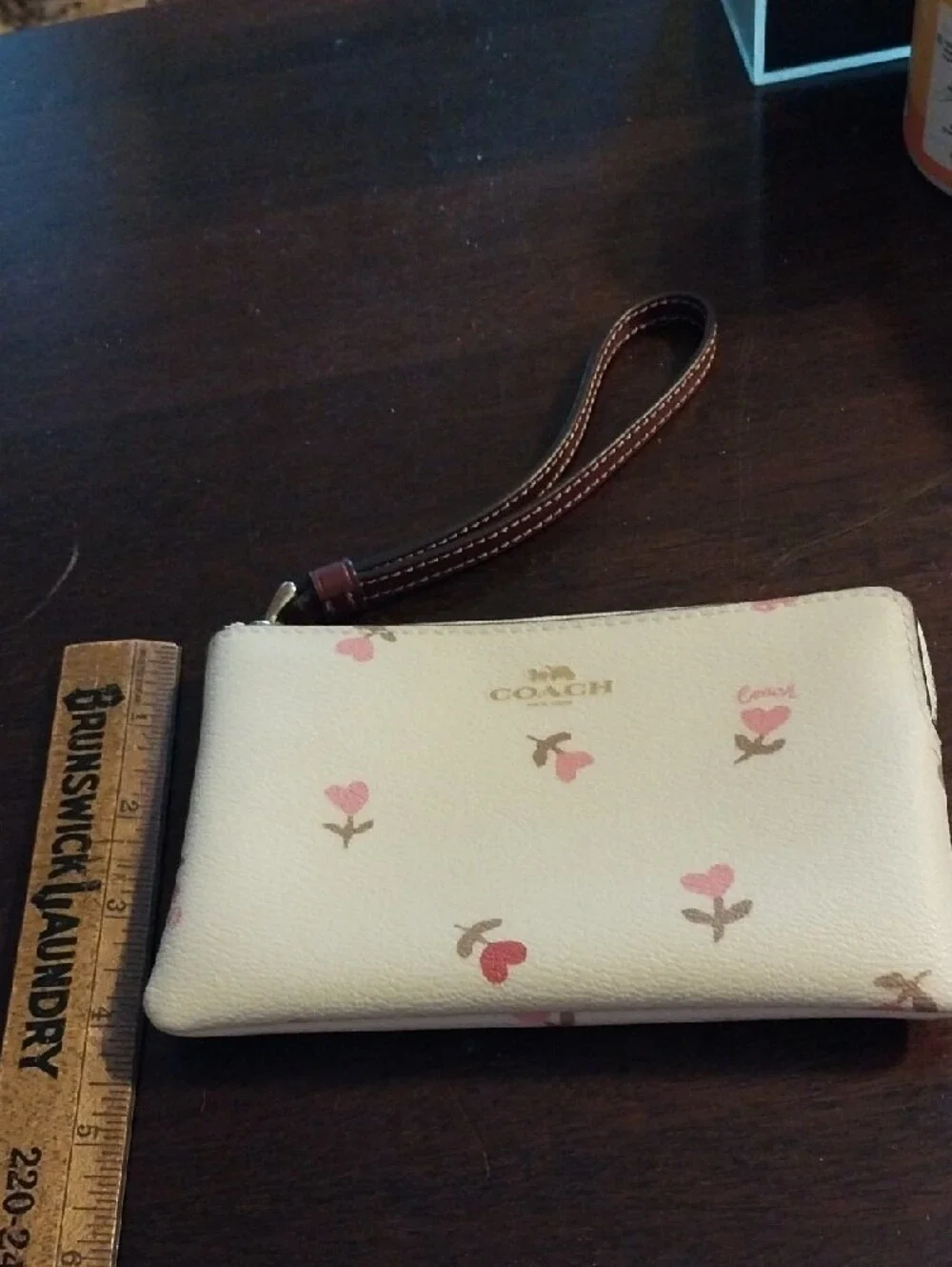 Coach Cream Wristlet with Pink Floral Accents and Brown Strap